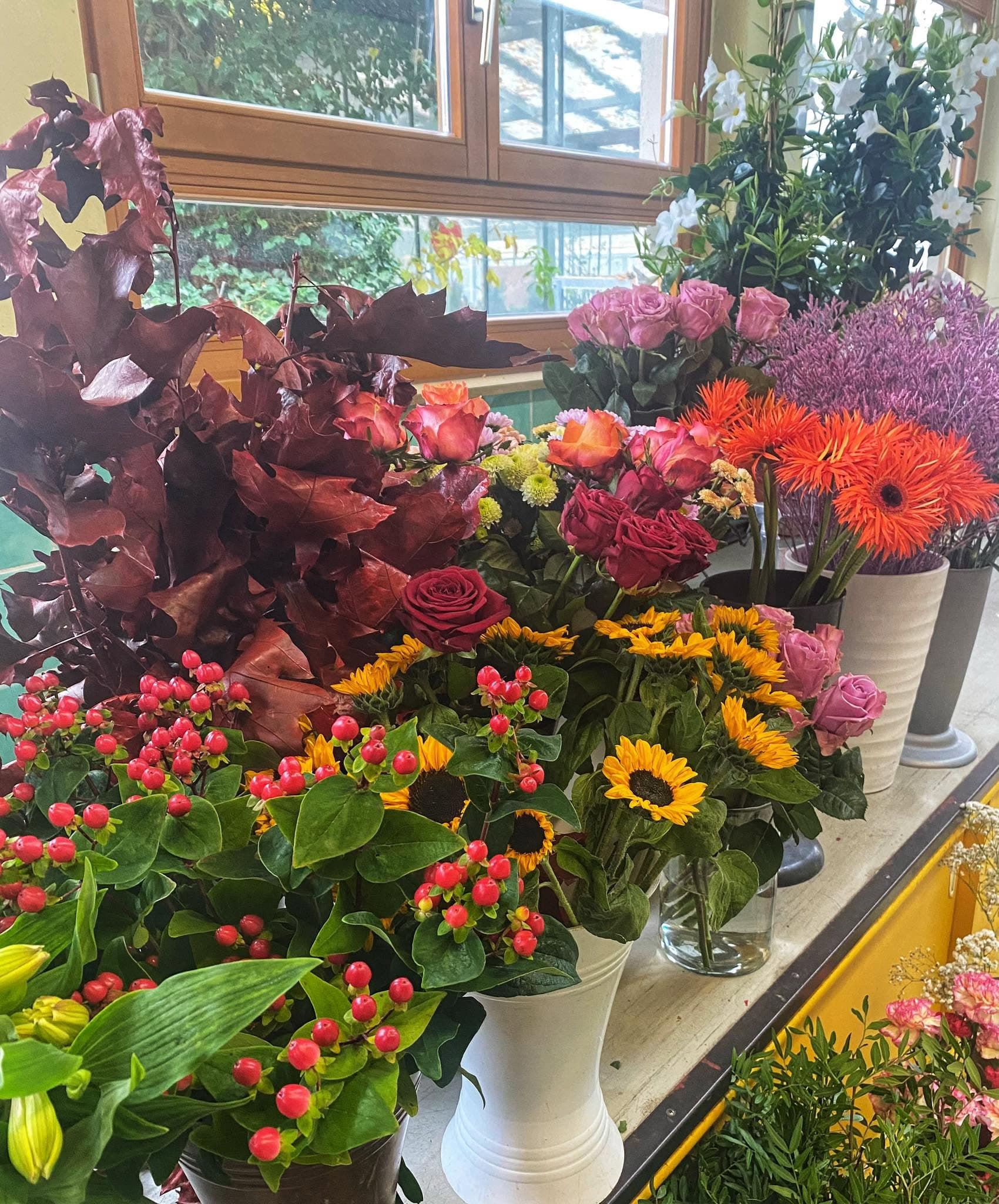 Herbstliche Schnittblumen in Vasen am Fenster des Blumenladens