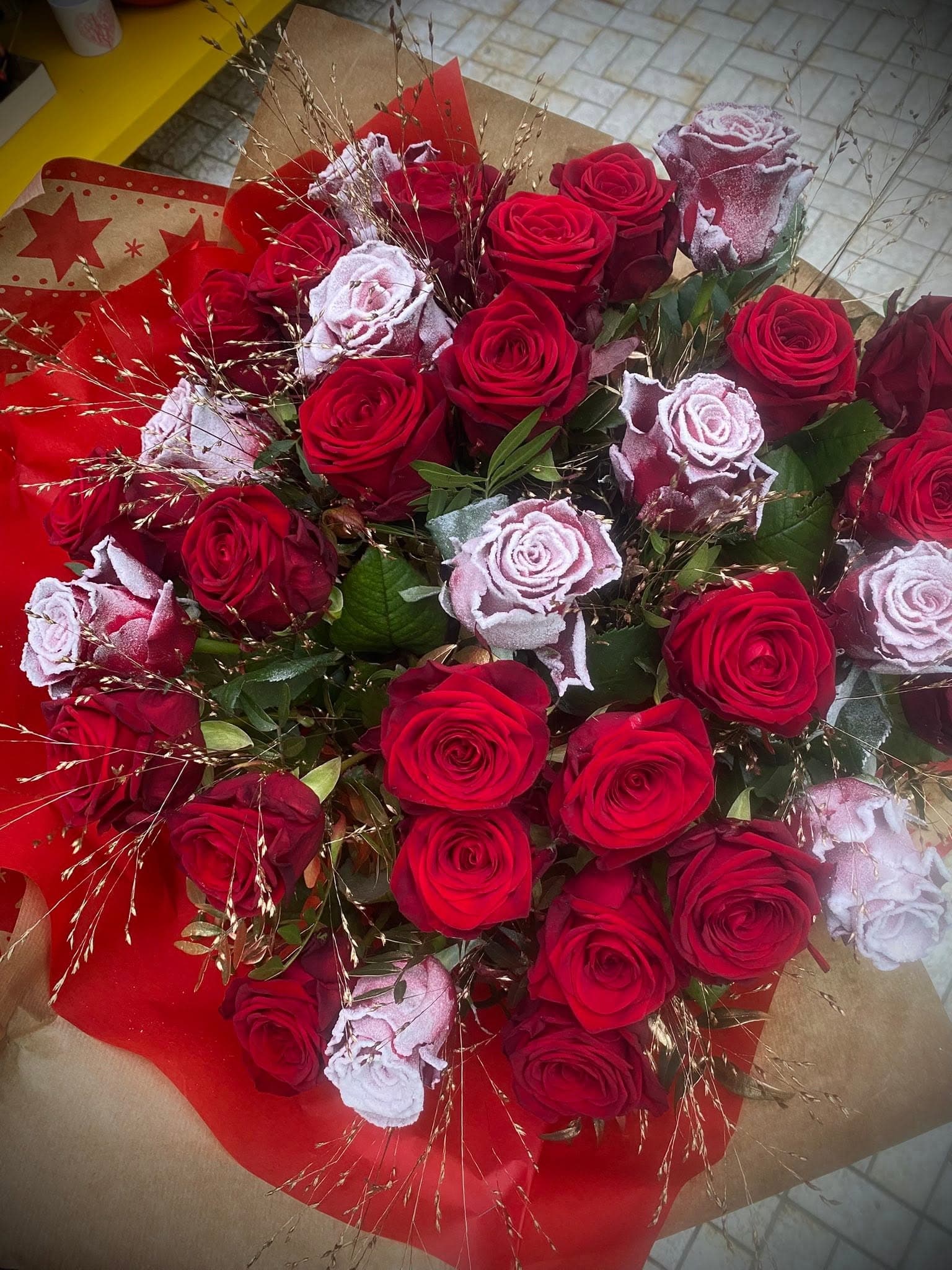 Großer Strauß aus roten und gefrosteten rosa Rosen mit Ziergras
